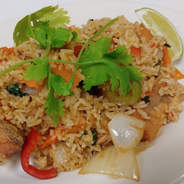 Siri Thai Cuisine's fried rice with vegetables, cilantro, and a lime wedge on a white plate.