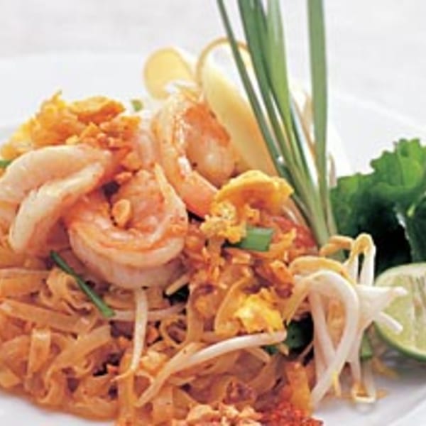 Siri Thai Cuisine's Pad Thai with shrimp, bean sprouts, lime, and green onions on a white plate.