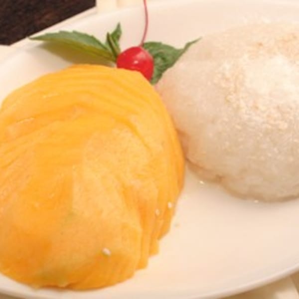 Siri Thai Cuisine's mango sticky rice dessert, garnished with a cherry and mint leaf.