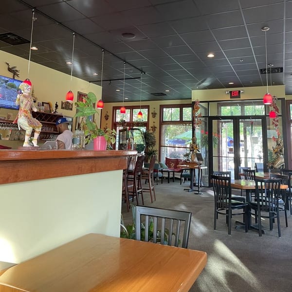 Interior of Siri Thai Cuisine, showing the bar area with a server and dining tables.